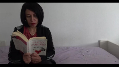 Brunette milf jerking off some cock while reading