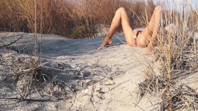 Thin bodied girl squirts masturbates in sand on the public beach