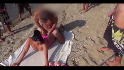 Hot naughty MILF gets a cumshot on the beach in front of a curious public after anal.