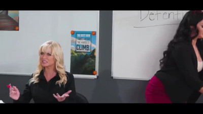 Short-haired harlot punishes bad girls right in the class
