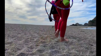 Two sporty girls with nice boobs ride mate's dick on a public beach