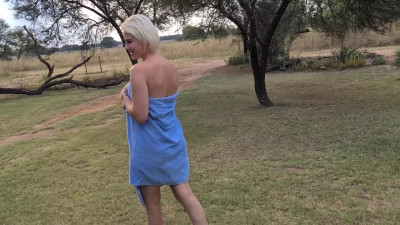 Lovely blond babe is washing herself while showering in nature